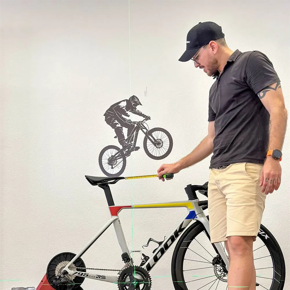 Victor a medir a altura do selim com fita métrica e linha laser, no estúdio VTR BIKE LAB, em Oeiras